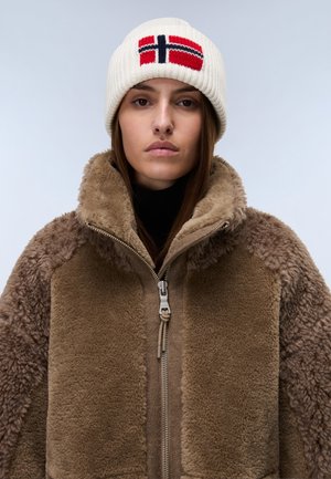 Giacca di felpa marrone con tessuto a trama, colletto alto e dettagli con zip. Berretto di lana bianco con design della bandiera norvegese in rosso e blu.