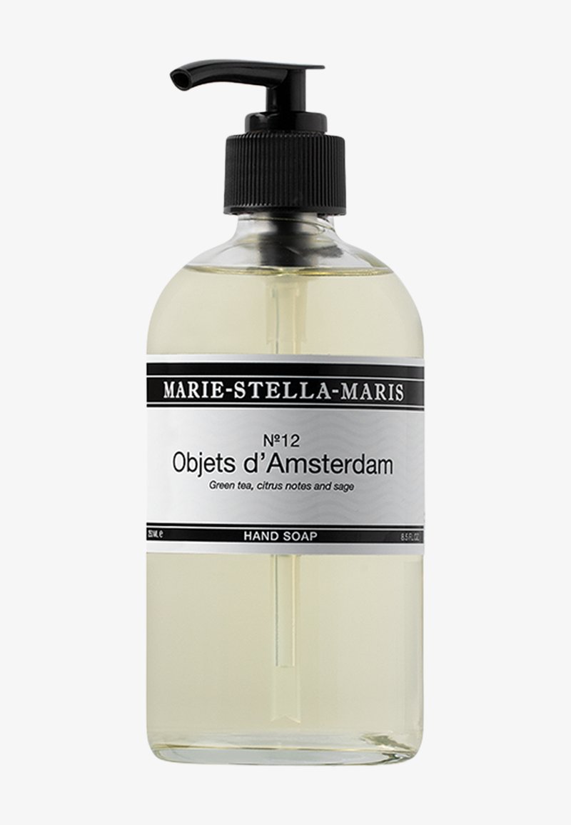 Bottiglia di vetro trasparente con pompette nera. L'etichetta presenta testo in bianco e nero. Contiene sapone liquido giallo chiaro con note di tè verde e salvia.