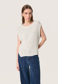 Top corto a maniche corte in maglia grigia chiara con texture a coste e vestibilità rilassata, abbinato a jeans a gamba larga blu scuro.