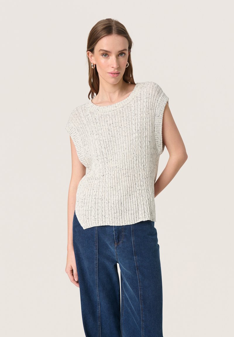 Top corto a maniche corte in maglia grigia chiara con texture a coste e vestibilità rilassata, abbinato a jeans a gamba larga blu scuro.