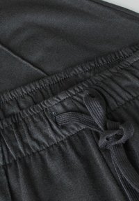 Donkergrijze joggingbroek met een elastische tailleband en een verstelbaar trekkoord, gemaakt van een zachte, textuurstof.