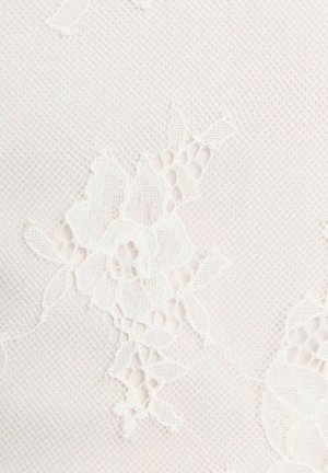 Tissu en dentelle blanche avec des motifs floraux et feuilles complexes sur un fond en maille fine.