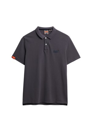 Polo de color gris oscuro hecho de algodón. Presenta un cuello con dos botones, logotipo bordado, mangas cortas y una pequeña etiqueta naranja en el lado izquierdo.