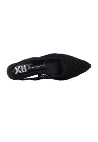 Zapato negro de punta puntiaguda con detalles de encaje; diseño fino con recortes; plantilla con marca. Textura suave con patrones intrincados.