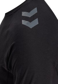 Maglietta sportiva nera con maniche corte, caratterizzata da una texture liscia e un design a chevron riflettente sulla spalla sinistra.