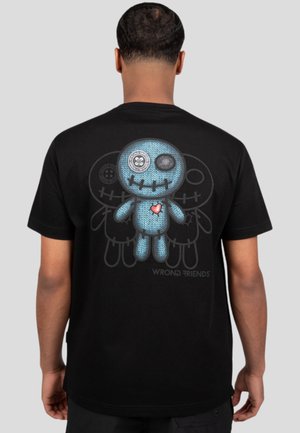 Black t-shirt featuring a graphic of a blue, knitted character with button eyes and a red heart on the back, with 'WRONG FRIENDS' text below.