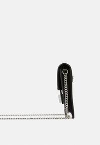 Borsa a mano in pelle nera con una forma rettangolare elegante. Presenta una tracolla in catena argentata e un design di chiusura minimalista.
