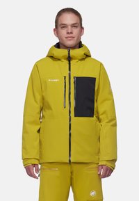 Gelbe wasserdichte Jacke mit einer schwarzen Brusttasche, Reißverschlüssen und einer verstellbaren Kapuze. Hergestellt aus weichem, strukturiertem Stoff für Langlebigkeit.
