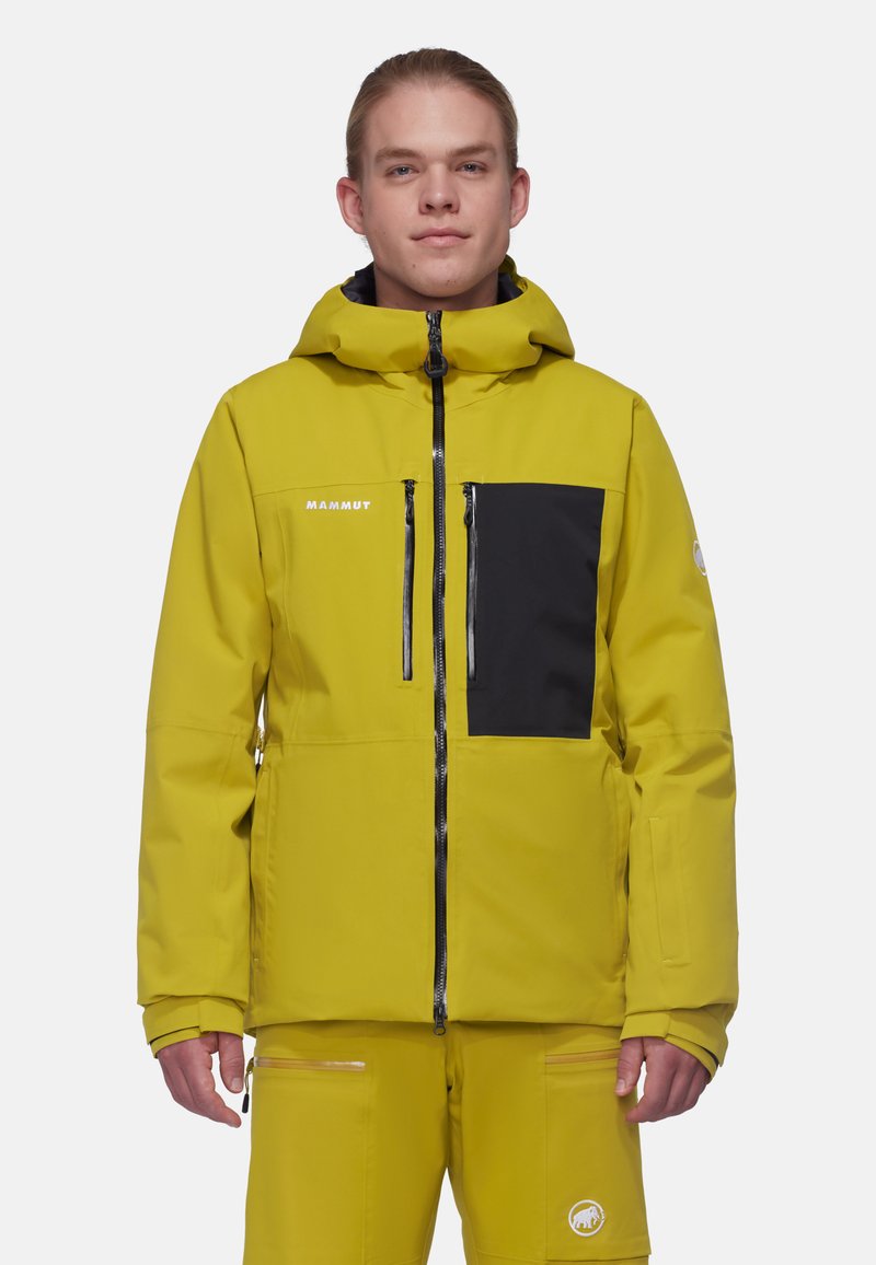 Gelbe wasserdichte Jacke mit einer schwarzen Brusttasche, Reißverschlüssen und einer verstellbaren Kapuze. Hergestellt aus weichem, strukturiertem Stoff für Langlebigkeit.