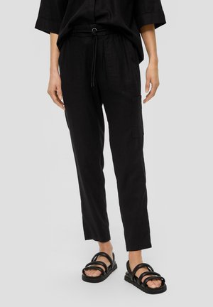 Zwarte linnen broek met een elastische tailleband, een trekkoorddetail en zijcargo zakken. Gecombineerd met zwarte sandaaltjes met bandjes.