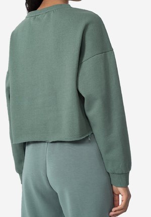 Geknipte, langslaper sweatshirt in een gedempt groene katoenmix. Heeft ribgebreide manchetten en een ruwe zoom. Zachte textuur met een oversized pasvorm.
