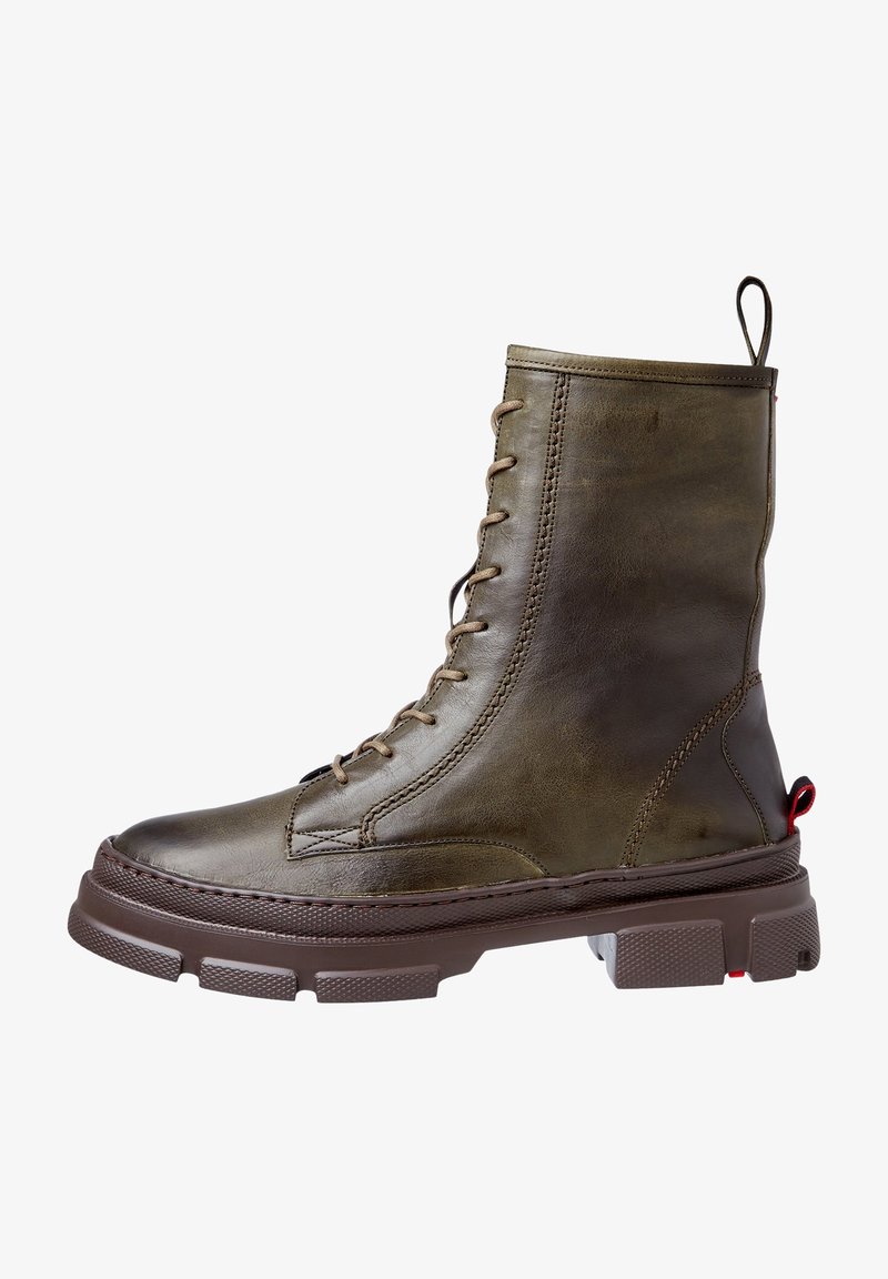 Botte de combat en cuir marron foncé à lacets, semelle épaisse et texturée, avec languette à l'arrière.