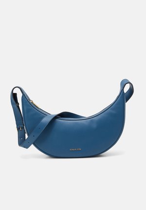 Sac à épaule en cuir bleu avec une silhouette courbée, accent logo doré et bandoulière réglable. Texture lisse avec une fermeture éclair sécurisée.