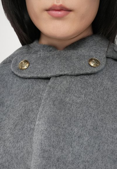 Capa de lã cinza com colarinho arredondado, apresentando dois botões dourados e uma textura suave. Perspetiva detalhada do tecido e dos detalhes do colarinho.