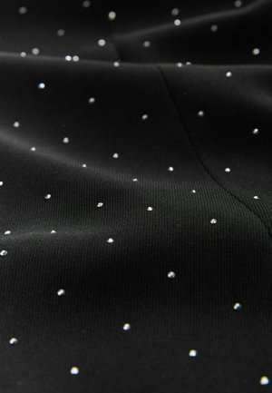 Černá tkanina se malými, lesklými rhinestones rovnoměrně rozmístěnými po povrchu, což vytváří texturovaný vzhled.