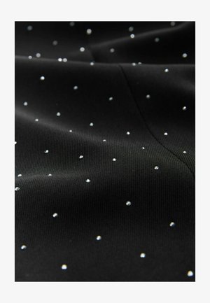 Tissu noir avec de petites pierres précieuses brillantes régulièrement espacées sur la surface, créant un aspect texturé.