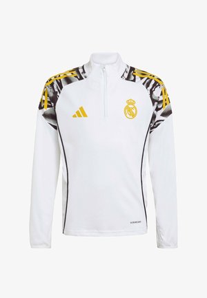 Biała bluzka z długim rękawem i suwakiem do ćwiartki, czarne i żółte akcenty oraz abstrakcyjny wzór na ramionach. Na przodzie znajduje się logo drużyny oraz napis „AEROREADY”.