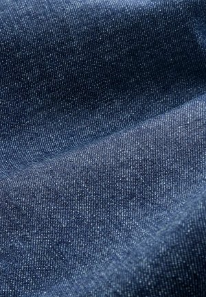 Marineblaues Denim-Gewebe mit glatter Textur und sichtbarem Webmuster; weist subtile weiße Punkte auf, die eine leichte Tonvariation anzeigen.