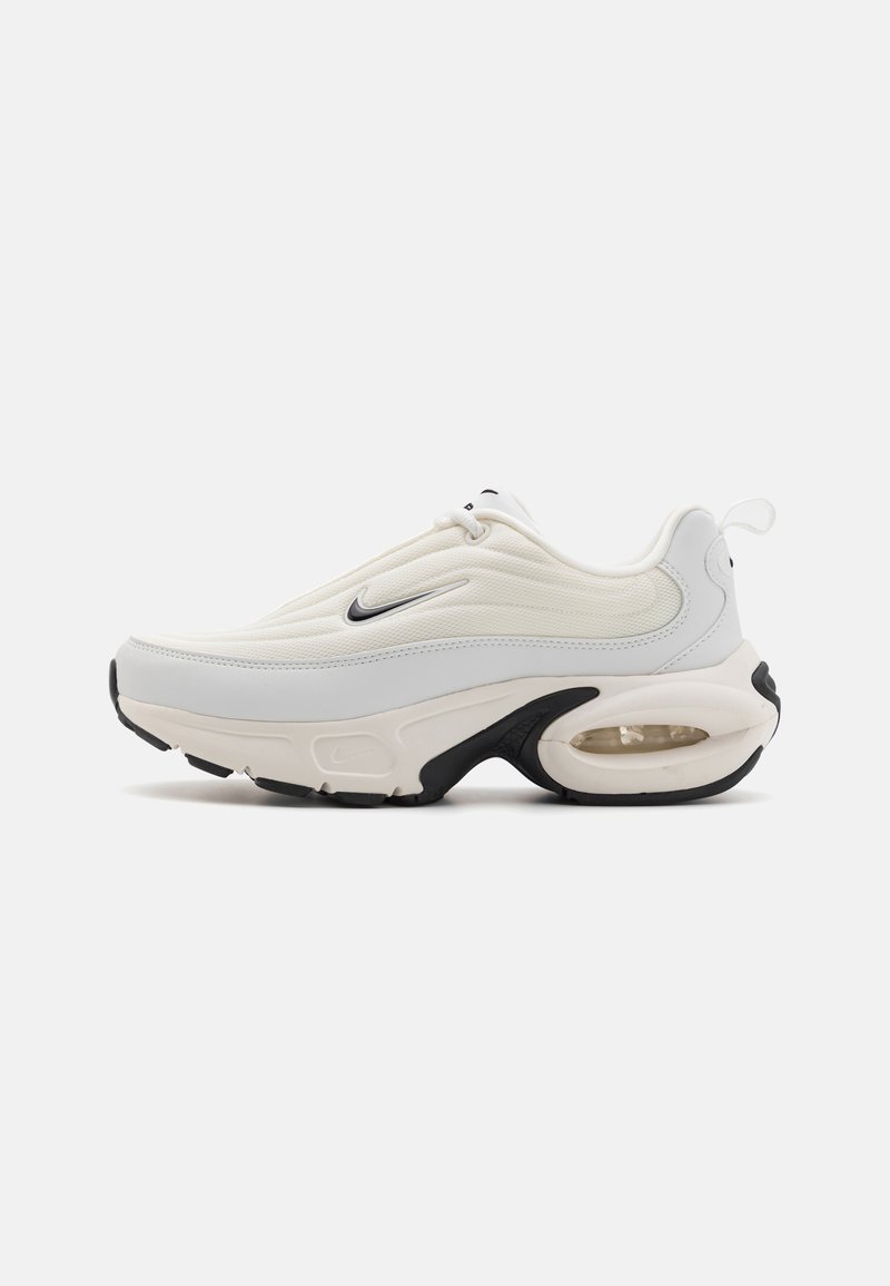Sneakers Nike w kolorze off-white i czarnym z teksturowaną cholewką, wyściełanym kołnierzem i widoczną poduszką powietrzną w podeszwie. Klasyczny design na sznurówki.