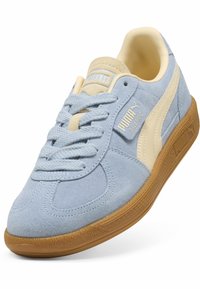Ανοιχτό γαλάζιο σουέτ sneaker Puma με κρεμ πλευρική ρίγα, καφέ σόλα, κρεμ γλώσσα και επωνυμία "Puma Palermo" στο πλάι.