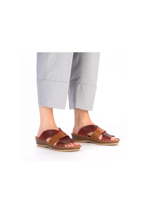 Brown and burgundy sandals with perforated leather straps and a textured sole. Rounded shape and stitched accents along the edge.