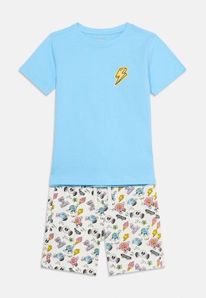 Tricou albastru cu mâneci scurte și fulger galben pe piept, asortat cu pantaloni scurți albi cu modele colorate de cranii de desene animate, flori și texte.