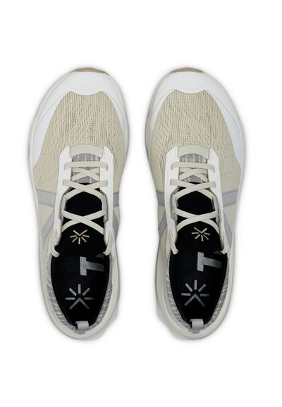 Baskets beige clair avec une tige en mesh texturé, des accents blancs, une semelle intérieure noire avec logo et des lacets contrastés. Design à bout rond.