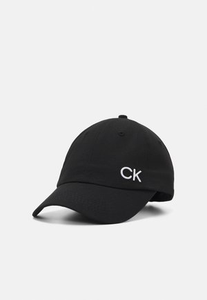 Cappellino da baseball in cotone nero con visiera curva e logo "CK" ricamato in bianco. Presenta sei pannelli e un occhio di ventilazione nella parte superiore.