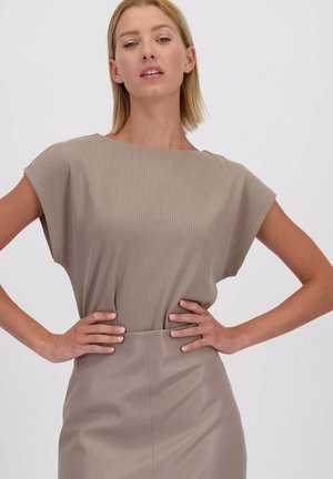 Beige ribbeltop met kapmouwen, gecombineerd met een beige leren rok. Glad textuur overal, met een relaxte pasvorm en een eenvoudig ontwerp.