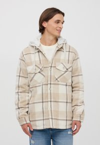 Giacca di flanella a quadri beige con cappuccio grigio, caratterizzata da un frontale con bottoni, due tasche sul petto e una texture morbida.