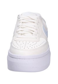 Sneaker bianca in pelle con punta perforata, lacci bianchi piatti e striscia blu chiaro. Suola spessa in gomma bianca texturizzata.
