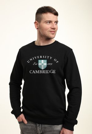 Felpa nera con la scritta "Università di Cambridge" e stemma, con polsini e orlo a costine, realizzata in un tessuto morbido e strutturato.