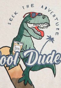 Grafisk T-shirt med en grøn dinosaur, der bærer røde solbriller, holder en drink, med teksten "Søg eventyret" og "Cool fyr."