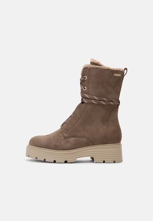 Bruine winterlaars tot halverwege de kuit met een voering van bont, veterluiting aan de voorkant en een stevige beige zool, geschikt voor koud weer.