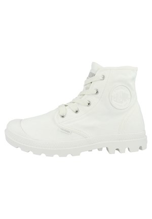 Bottines en toile blanches montantes avec un design à lacets, embout en caoutchouc et semelle texturée. Présente un patch logo circulaire sur le côté.