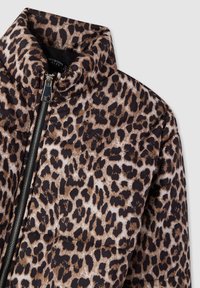 Giacca puffer con stampa leopardata, colletto alto e zip frontale nera.
