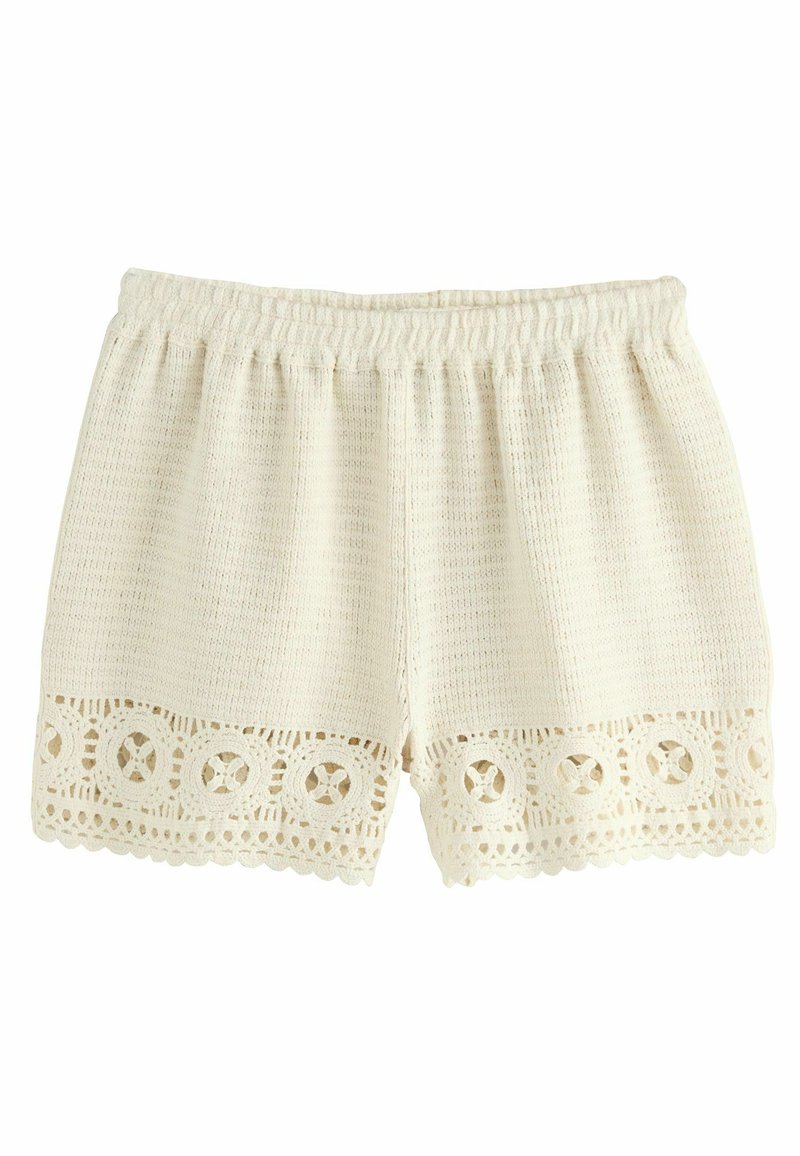 Weiße Strickshorts mit einem elastischen Bund und Spitzenbesatz am Saum, die kreisförmige Ausschnittmuster an den Rändern aufweisen.