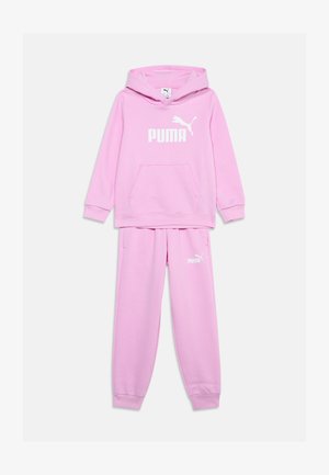 Chándal Puma de color rosa claro con capucha y pantalones a juego, con el logo blanco de Puma en el pecho y el muslo izquierdo.