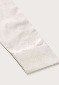 White cotton shirt cuff with a smooth texture, featuring a clean edge and subtle stitching detail.