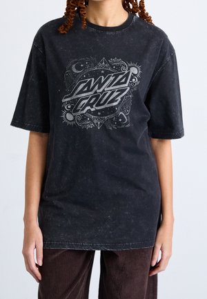 Czarny, oversize'owy T-shirt z graficznym wzorem w kolorze srebrnym, zawierającym skomplikowane wzory oraz wyraźny napis „SANTA CRUZ”.