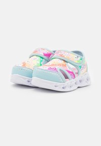 Jasnoniebieskie sandały z różowym górnym wykończeniem w tęczowy wzór, regulowanym paskiem i białą, dekorowaną sercami podeszwą. Zaprojektowane z myślą o komforcie i wsparciu.