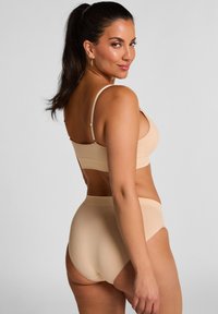 Nude-kleurige lingerieset met een bh met dunne bandjes en een high-waisted slipje. Glad materiaal met minimale details, ontworpen voor comfort.