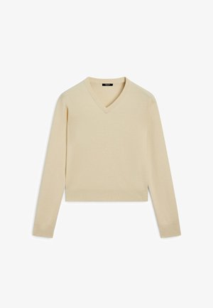 Beżowy sweter na drutach z dekoltem w serek, krótki fason, długie rękawy, prążkowane mankiety i dół, gładka tekstura, minimalistyczny styl.