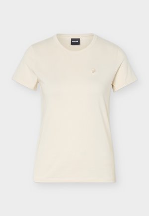 Majica kratkih rukava boje kreme s uskim okruglim izrezom i malim izvezenim logotipom na lijevoj strani prsa te crnom etiketom "BOSS" unutar ovratnika.