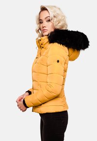 Yellow puffer jacket with a black faux fur hood, zip closure, and quilted texture. Features fitted cuffs and side pockets.