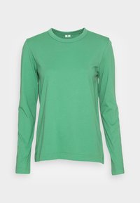 Maglietta verde a maniche lunghe realizzata in tessuto morbido e elastico. Presenta un colletto rotondo e polsini a coste. Texture liscia senza motivi visibili.