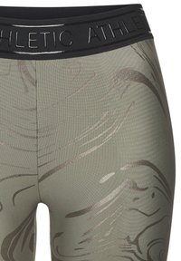 Grüne Sportleggings mit einem schwarzen elastischen Bund. Enthält texturierte, metallische Muster in Bronzetönen. Glatter, elastischer Stoff.