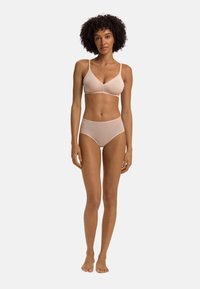 Bralette wireless beige con spalline sottili, slip high-waisted abbinati. Tessuto liscio e elasticizzato, design minimal, finitura senza cuciture.