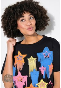 Sort t-shirt med farverige stjernemønstre i orange, pink, blå og gul, med en løs pasform og korte ærmer. Fremstillet af bomuld.