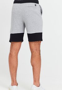 Grå bomuldsblandingsshorts med en sort nederste sektion, prydet med en hvid accent-syning og en baglomme. Glat tekstur, afslappet pasform.